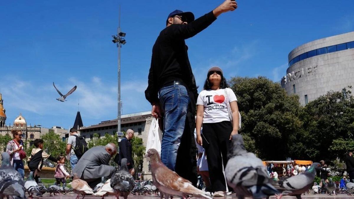 Dos turistas se fotografían en la Plaza de Cataluña de Barcelona/ AFP/Archivos