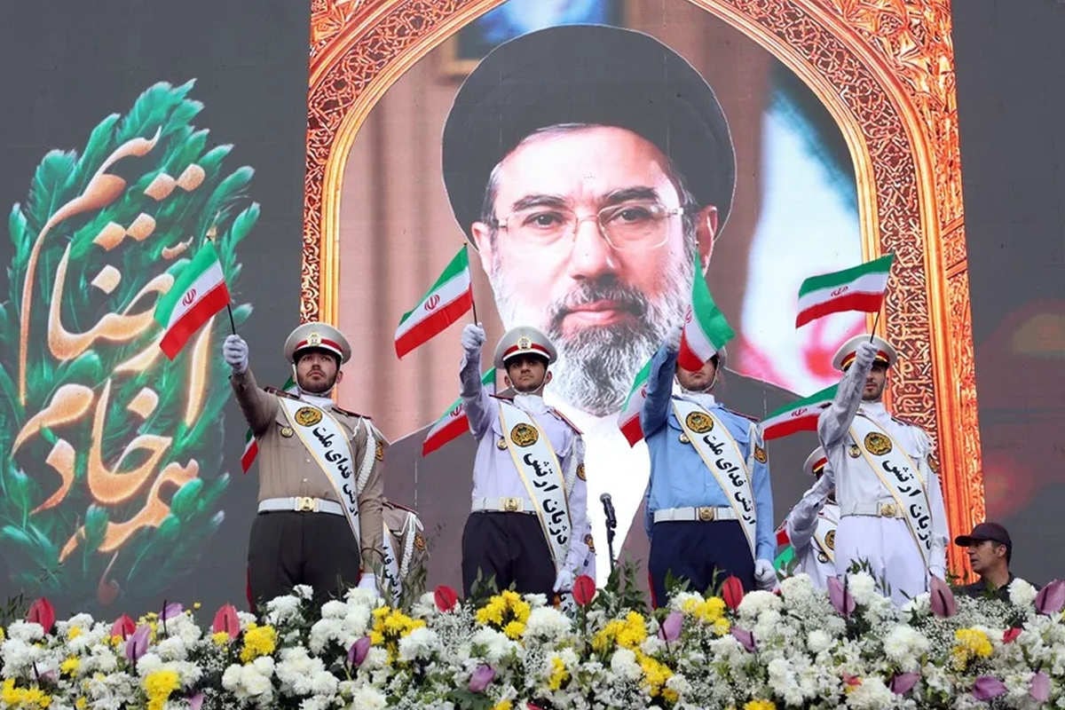 Miembros del ejército iraní ondean banderas nacionales frente a un cartel del líder supremo iraní, el ayatolá Mojtaba Jamenei. Foto: EFE/EPA/Abedin Taherkenareh