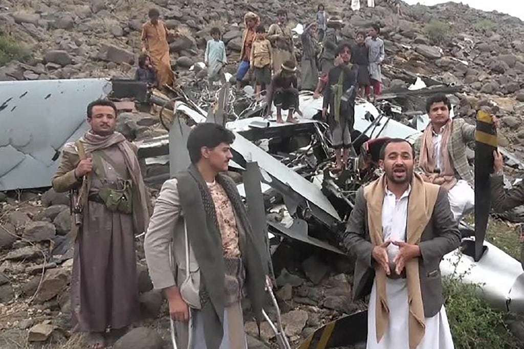 Esta fotografía, publicada por el Centro de Medios Huthi Ansarullah de Yemen el 4 de agosto de 2024, muestra a combatientes de pie alrededor de lo que, según ellos, son los restos de un dron estadounidense MQ-9 Reaper que derribaron sobre la provincia de Saada. (Foto: ANSARULLAH MEDIA CENTRE / AFP)