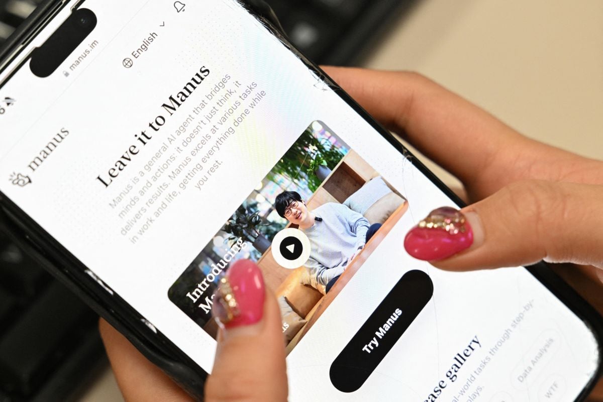 Una ilustración fotográfica tomada en Pekín el 11 de marzo de 2025 muestra un teléfono móvil en el que se ve la pantalla de presentación de Manus, una herramienta de asistente de IA lanzada por la startup china Butterfly Effect. China ha bloqueado la adquisición de la startup de IA Manus por parte de Meta, según informó el principal organismo de planificación económica del país el 27 de abril de 2026, tras las noticias aparecidas el mes pasado en los medios de comunicación según las cuales Pekín había impedido a dos de los cofundadores salir del país. (Foto de ADEK BERRY / AFP)