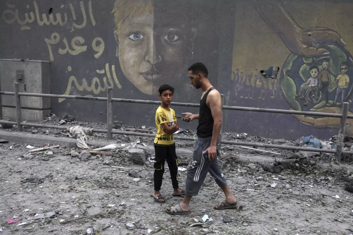 Unos palestinos caminan entre los escombros en Gaza el 9 de octubre de 2023, tras unos bombardeos de Israel (Foto: AFP)