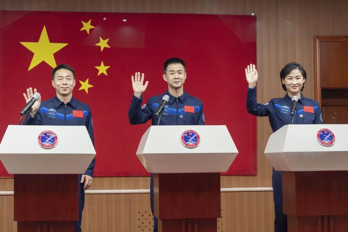 En esta imagen, distribuida por la agencia noticiosa Xinhua, los astronautas chinos (de izquierda a derecha) Cai Xuzhe, Chen Dong y Liu Yang, saludan durante una conferencia previa al lanzamiento de la misión Shenzhou-14, en el centro de lanzamiento satelital de Jiuquan, en el noroeste de China. (Cai Yang / Associated Press)