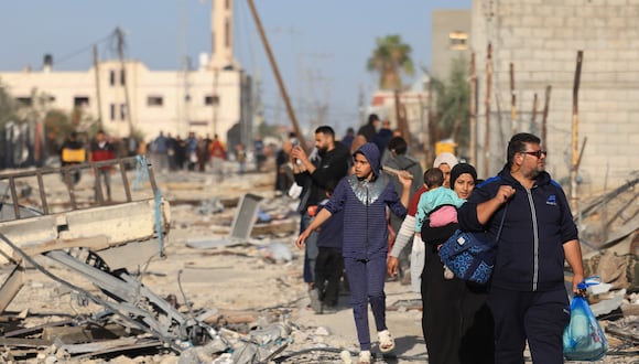 Palestinos caminan entre escombros a su regreso a Khan Yunis para inspeccionar sus hogares después de semanas de bombardeos israelíes, en el distrito de Khezaa, en las afueras orientales de la ciudad del sur de la Franja de Gaza, el 24 de noviembre de 2023. (Foto de MAHMUD HAMS / AFP)