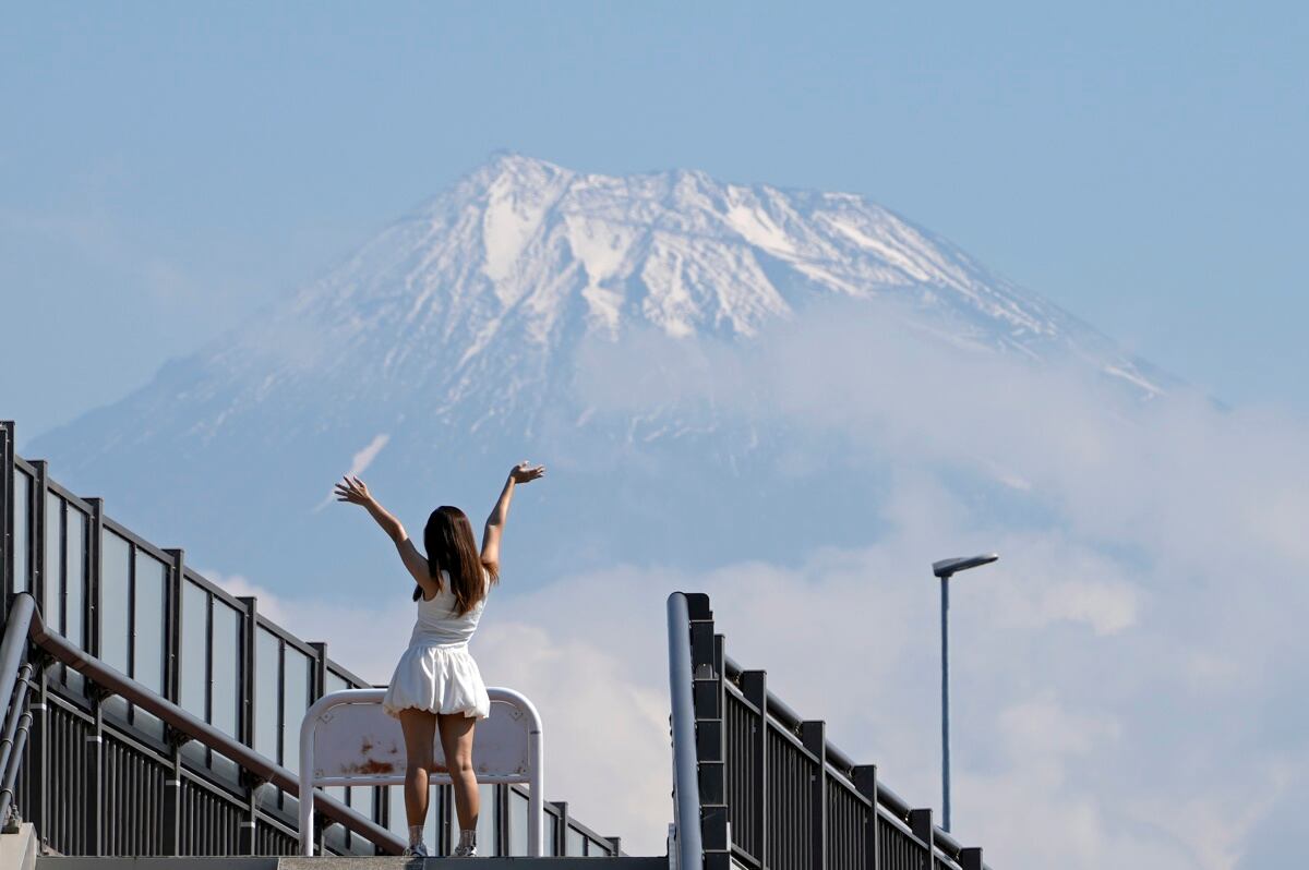 Una turista posa en lo alto de las escaleras que conducen al Fujisan Yumeno Ohashi, o 'Puente del Gran Sueño del Monte Fuji', en tanto se ve el Monte Fuji al fondo, en la ciudad de Fuji, prefectura de Shizuoka. Este lugar ha ganado popularidad entre los visitantes extranjeros debido a su vista del Monte Fuji, que se ha vuelto viral en las redes sociales. EFE/ Franck Robichon
