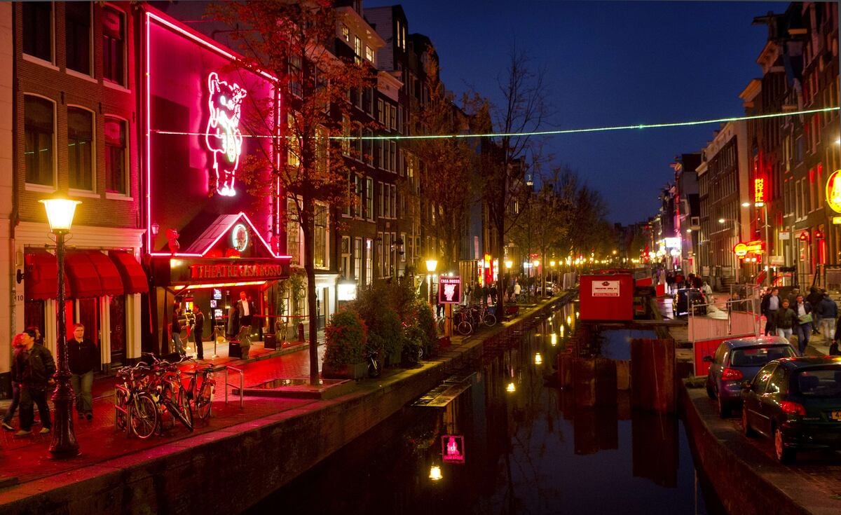 La gente camina por el barrio rojo, conocido como De Wallen, en Ámsterdam, el 13 de octubre de 2011. De Wallen es el barrio rojo más grande del centro de Ámsterdam y una importante atracción turística. El ayuntamiento de Ámsterdam ha iniciado un proyecto para adquirir inmuebles en el barrio con el fin de diversificar los negocios y reducir la delincuencia. AFP PHOTO / ANP / KOEN VAN WEEL