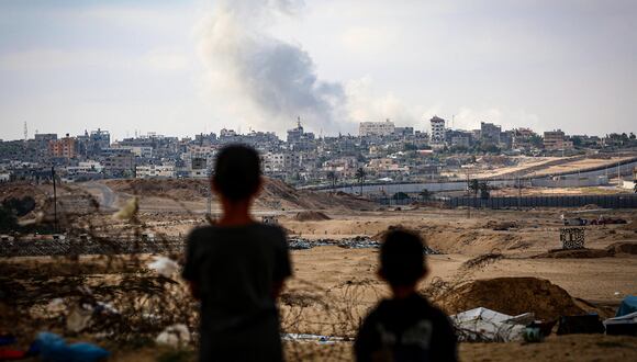 Los niños observan el humo que se eleva durante los ataques israelíes al este de Rafah, en el sur de la Franja de Gaza, el 13 de mayo de 2024, en medio del conflicto en curso entre Israel y el grupo militante palestino Hamás. (Foto de AFP)