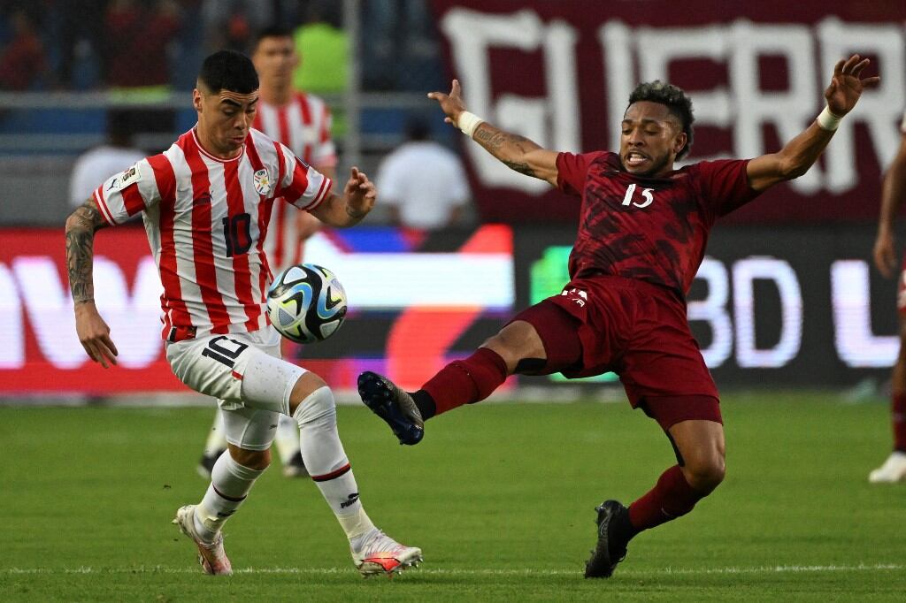 Paraguay's midfielder Miguel Almiron (L) fights for the ball with Venezuela's midfielder Jose Martinez during the 2026 FIFA World Cup South American qualifiers football match between Venezuela and Paraguay, at the Monumental stadium in Maturin, Venezuela, on September 12, 2023. (Photo by Yuri CORTEZ / AFP)