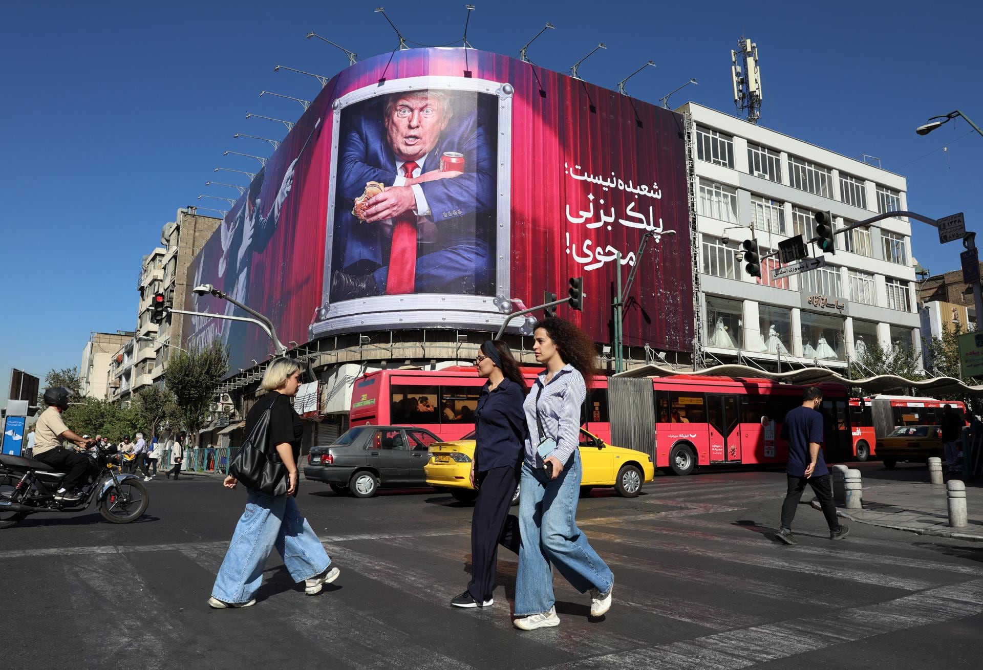 Iraníes pasan junto a una valla publicitaria contra Donald Trump en una calle de Teherán, Irán, el 23 de septiembre de 2026. (EFE/EPA/ABEDIN TAHERKENAREH).