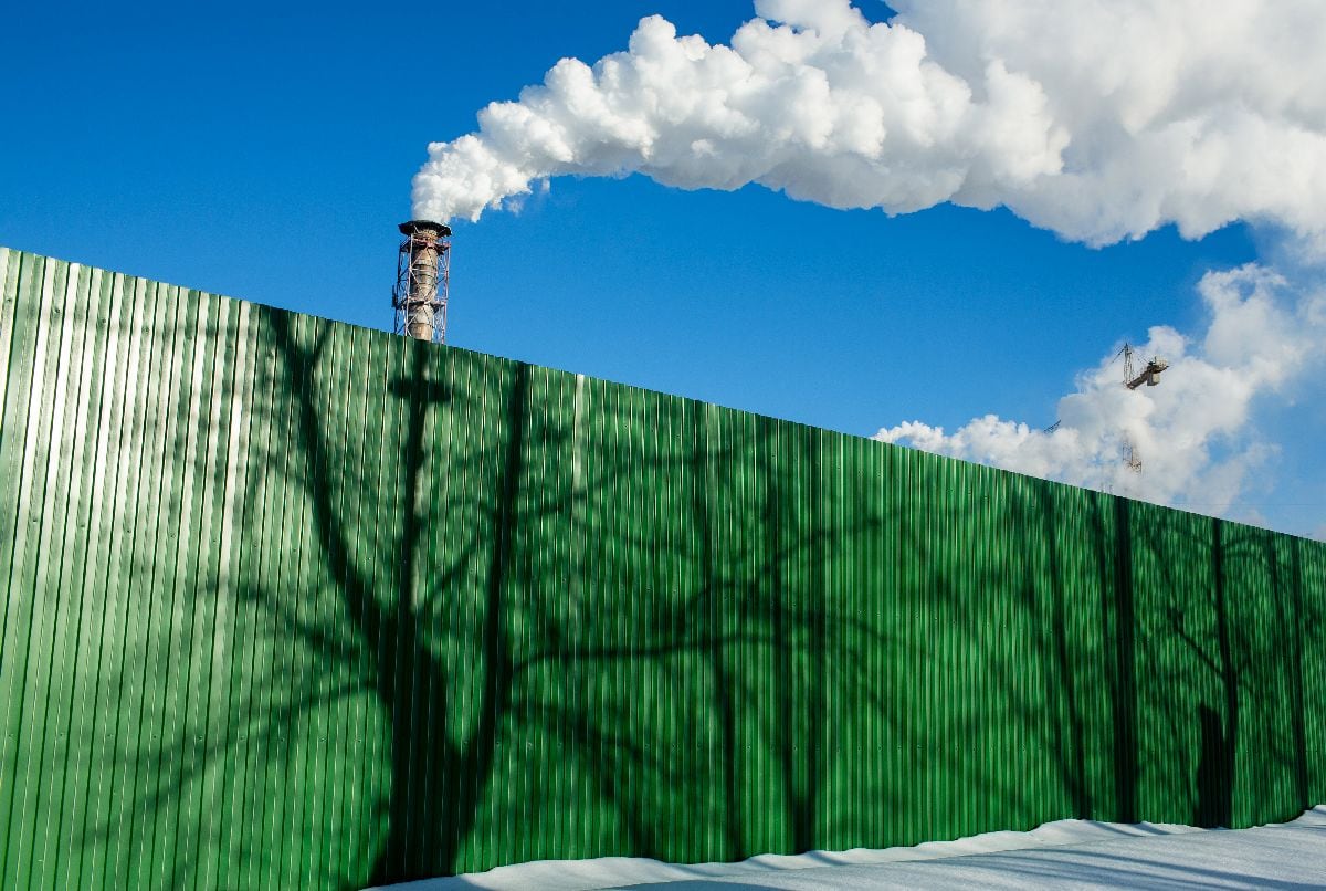 Valla verde delante de chimeneas. Fotógrafo: Andrey Rudakov/Bloomberg