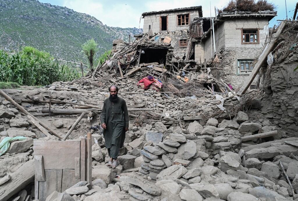 Un hombre afgano pasa junto a una casa dañada tras los terremotos en la aldea de Mazar Dara, en Nurgal, distrito de la provincia de Kunar, en el este de Afganistán, el 1 de septiembre de 2025. (Foto de Wakil Kohsar / AFP)