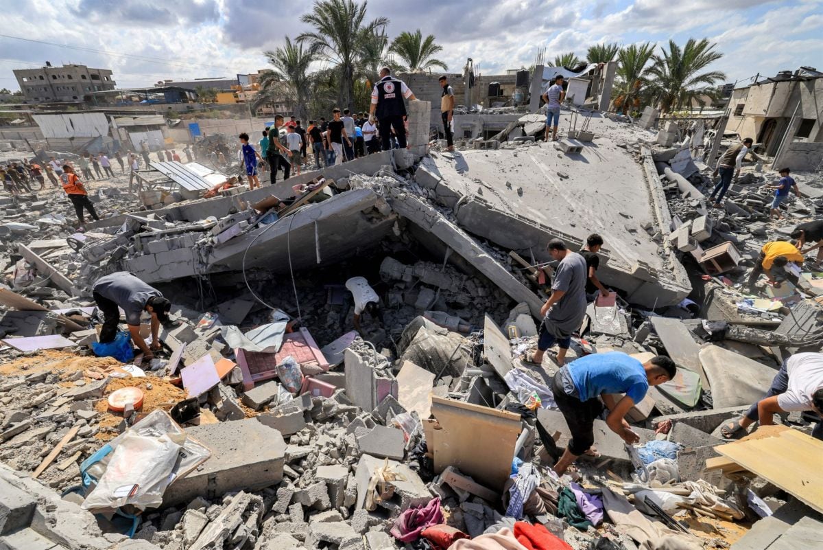La gente inspecciona los restos de un edificio destruido en Khan Yunis, al sur de la Franja de Gaza. Fotógrafo: Mahmud Hams/AFP/Getty Images