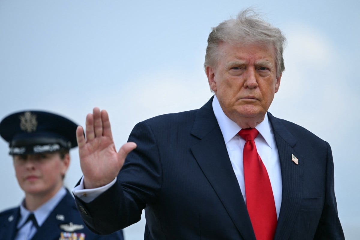 El presidente estadounidense Donald Trump saluda mientras sube al Air Force One en la base conjunta Andrews, Maryland, el 27 de julio de 2026. (Brendan SMIALOWSKI / AFP)