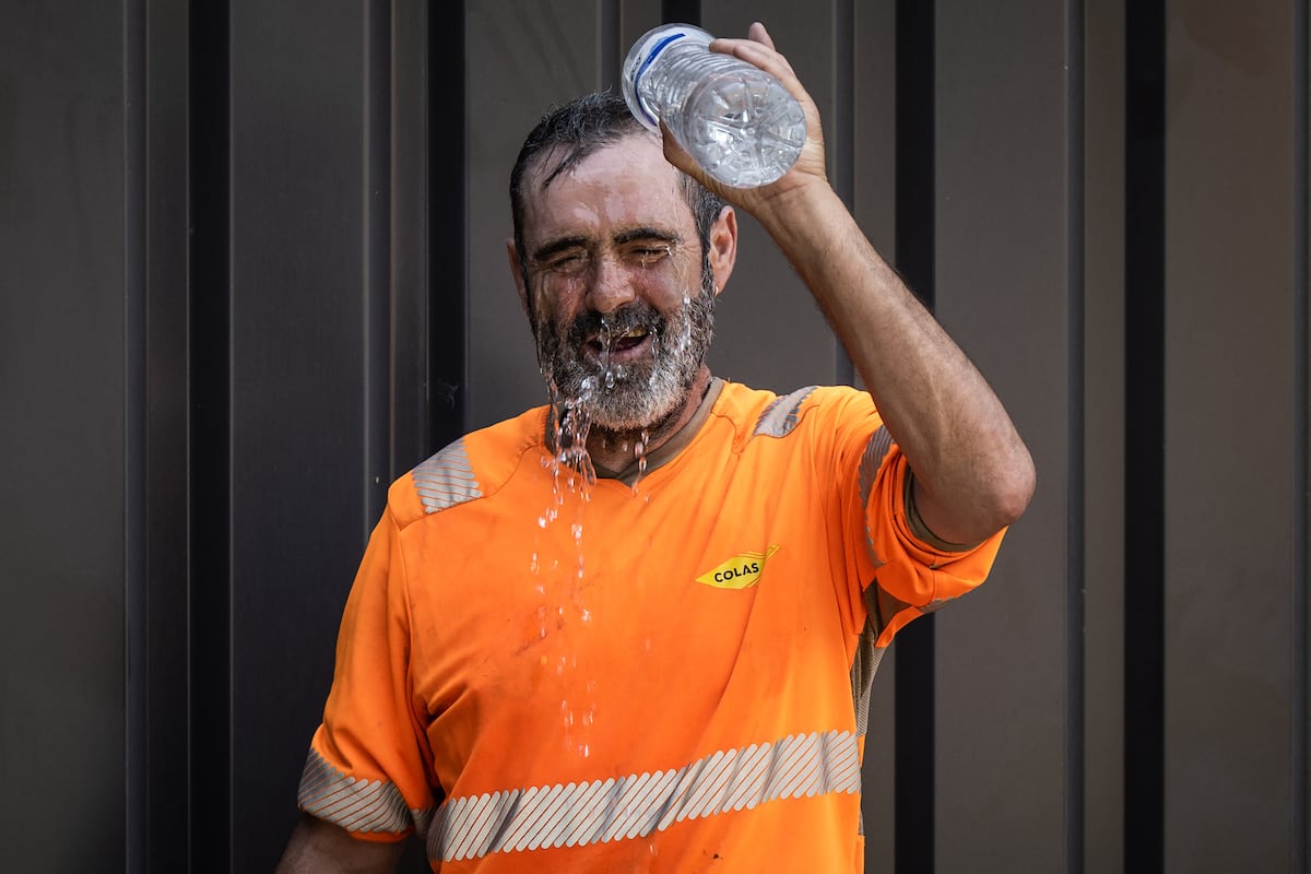 Un obrero se refresca en una construcción en Savenay, en las afueras de Nantes, el 18 de julio de 2022, cuando una ola de calor azota Francia (Foto: Loic VENANCE / AFP)