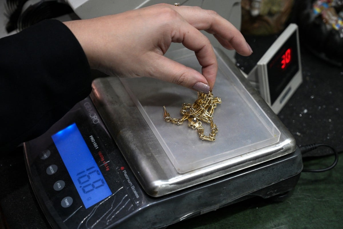 Un tasador pesa joyas de oro en una joyería de Buenos Aires el 6 de junio de 2024. (Foto por JUAN MABROMATA / AFP)