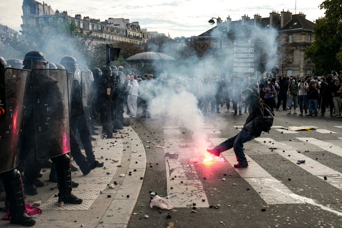 Una persona patea una bengala contra los agentes de policía que dispersan a los manifestantes al final de una protesta que forma parte de una jornada nacional de movilizaciones convocada por estudiantes de secundaria, el 6 de octubre de 2026. Foto: DIMITAR DILKOFF / AFP