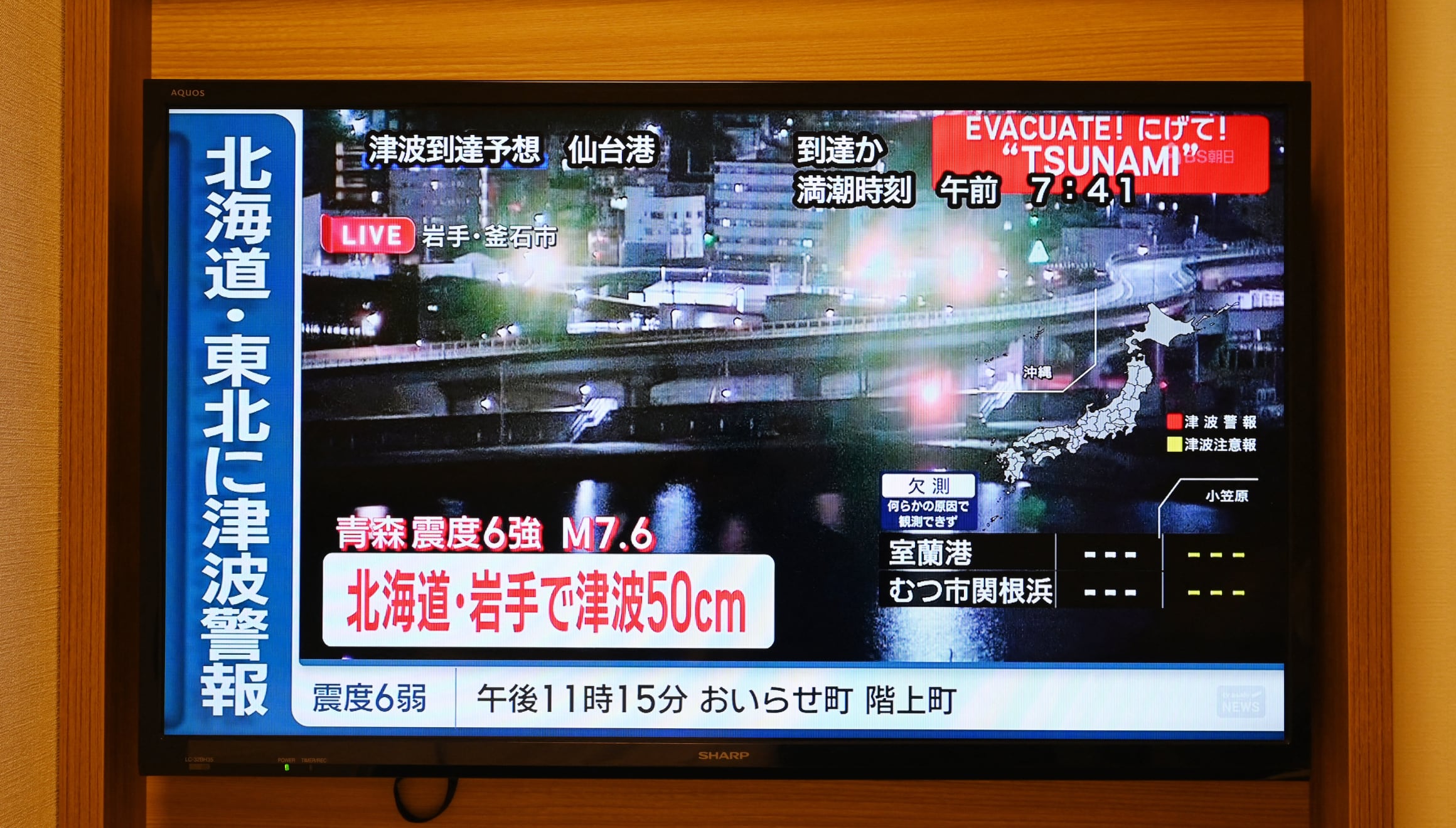 Una alerta de tsunami se proyecta sobre imágenes en directo de una zona costera en una pantalla de televisión en Sapporo, en la prefectura de Hokkaido, al norte de Japón, el 9 de diciembre de 2025. Un gran terremoto sacudió la costa norte de Japón el 9 de diciembre. La agencia meteorológica del país registró varias olas de tsunami y los medios locales informaron de heridos. | Crédito: Greg Baker / AFP
