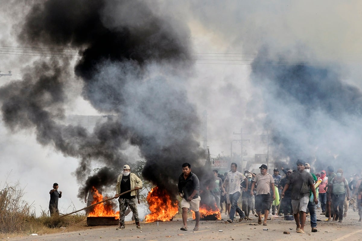 Manifestantes antigubernamentales se enfrentan a policías y civiles durante una operación para despejar un bloqueo de carretera en San Julián. (Rodrigo URZAGASTI / AFP)
