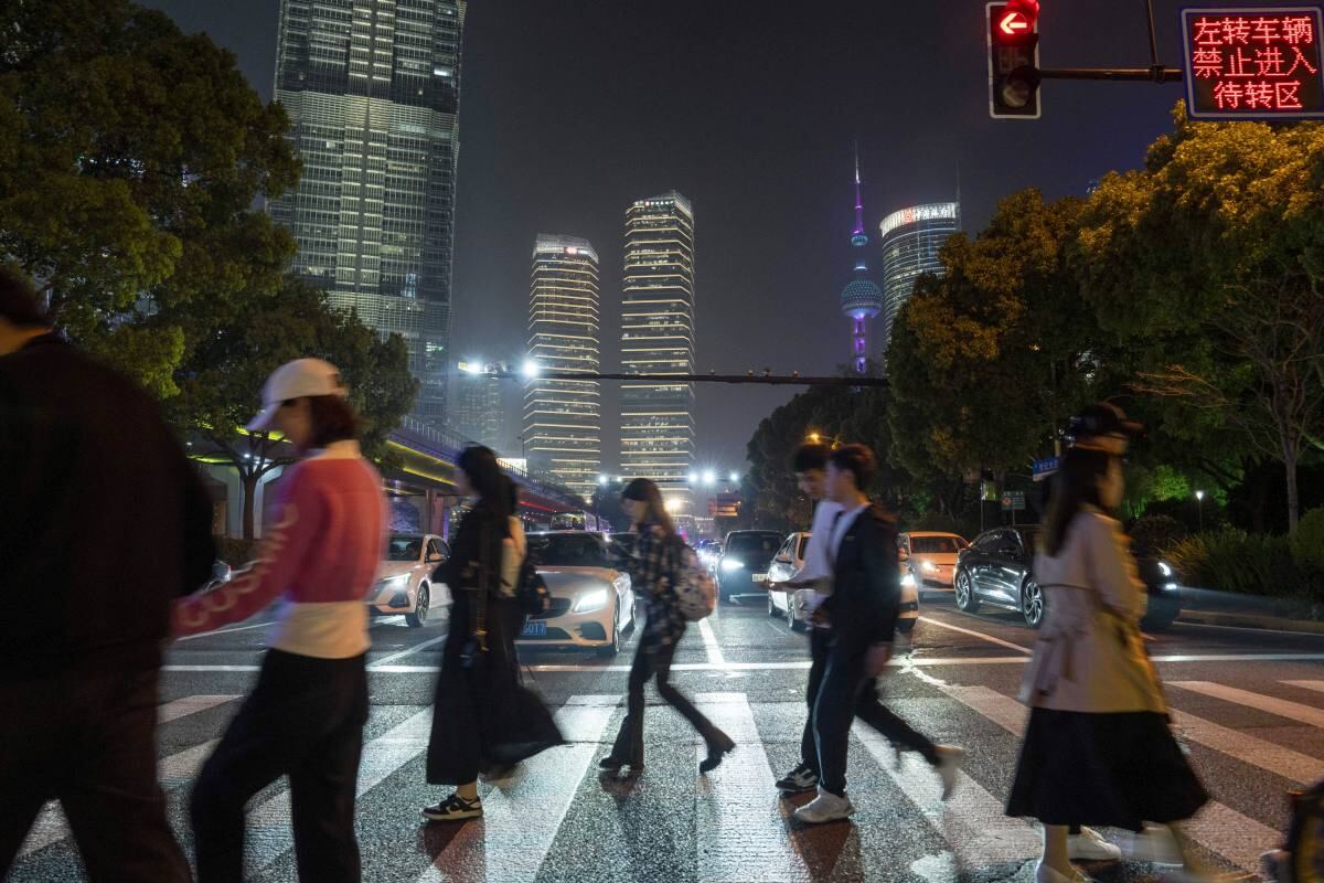 Pedestrians cross a road in Pudong's Lujiazui Financial District in Shanghai, China, on Monday, April 15, 2024. China's economic growth beat expectations in the first quarter as the industrial sector powered forward, although a tail-off in March activity signaled more support may be needed to sustain that momentum. Photographer: Raul Ariano/Bloomberg
