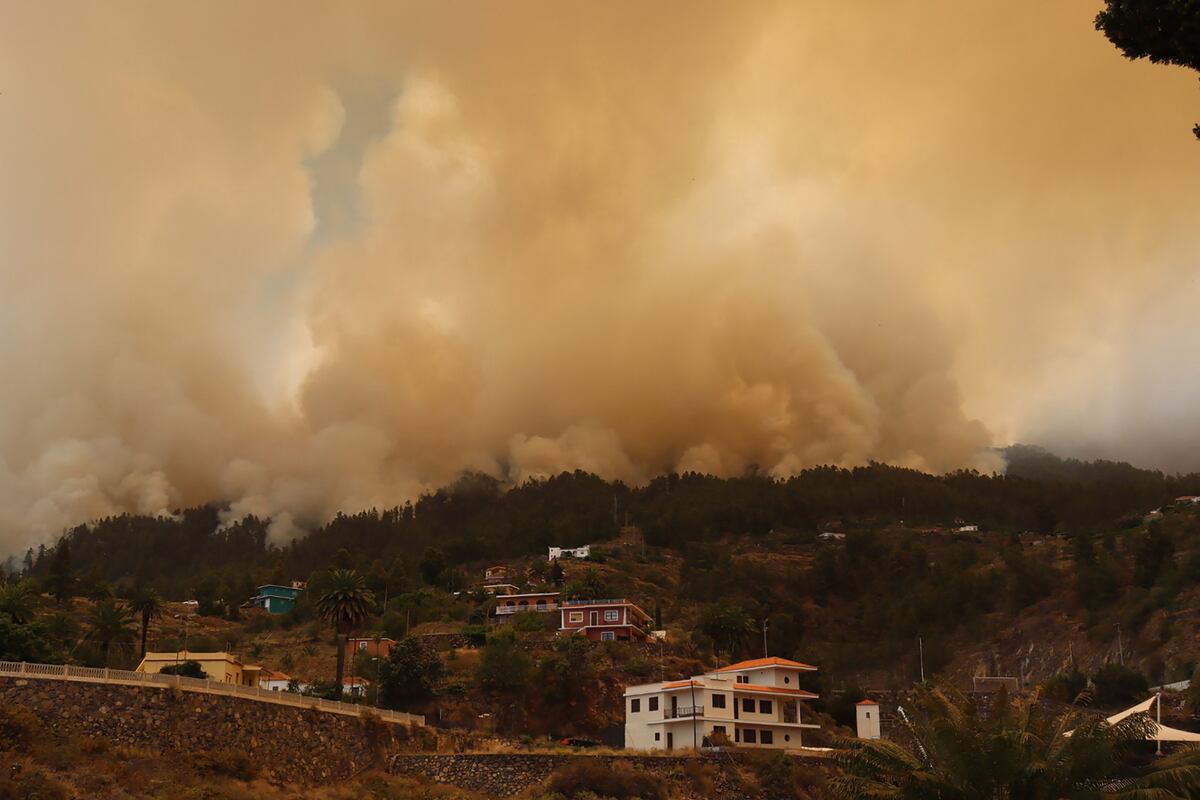 Una fotografía tomada el 15 de julio de 2023 en la isla canaria española de La Palma muestra la ciudad evacuada de Tijarafe rodeada de humo que sale de un incendio forestal cerca del Parque Nacional La Caldera de Taburiente. (Foto de STRINGER / AFP)