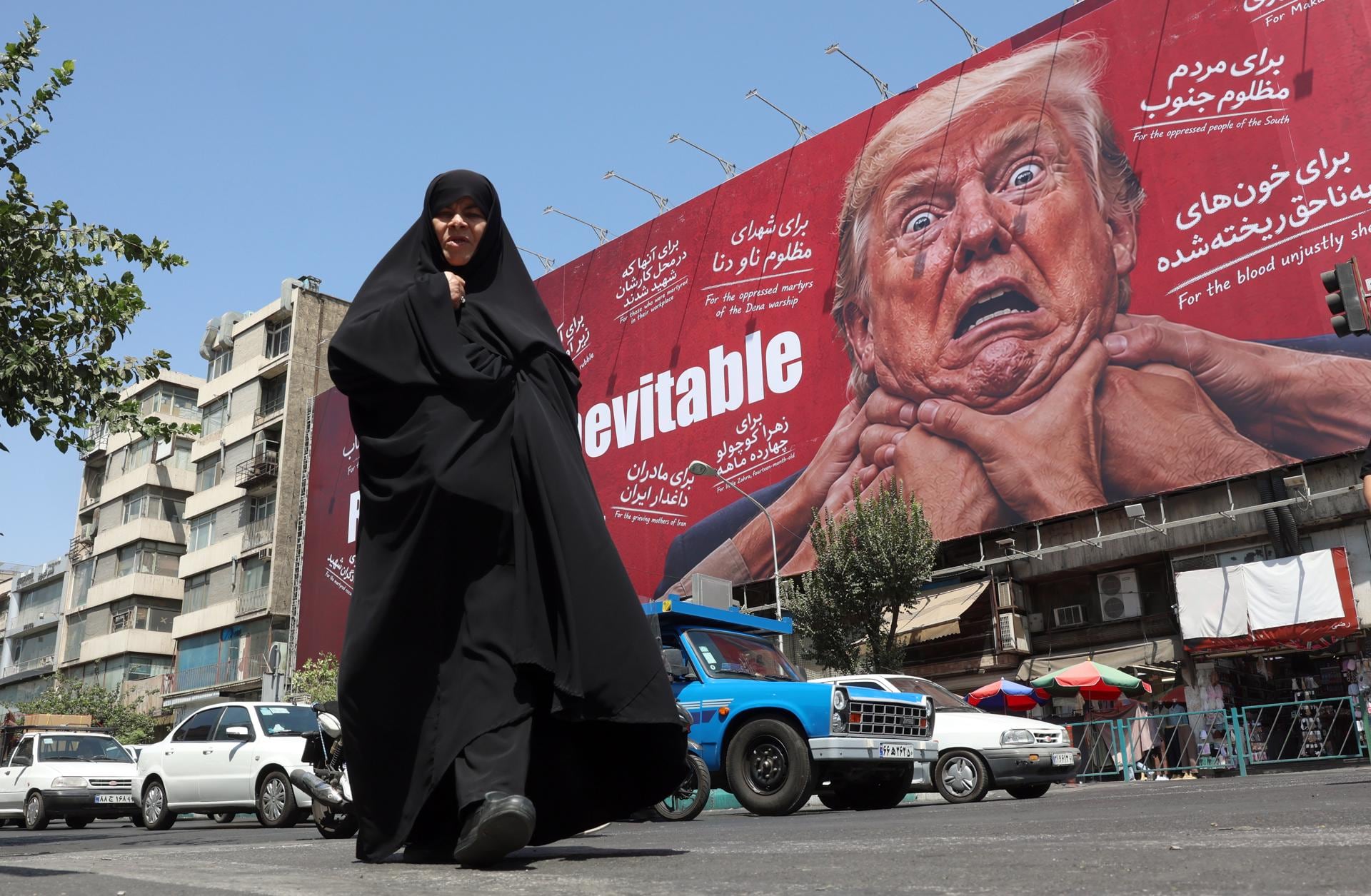Una mujer camina junto a una valla publicitaria contra Donald Trump en Teherán, Irán, el 19 de agosto de 2026. (EFE/EPA/ABEDIN TAHERKENAREH).