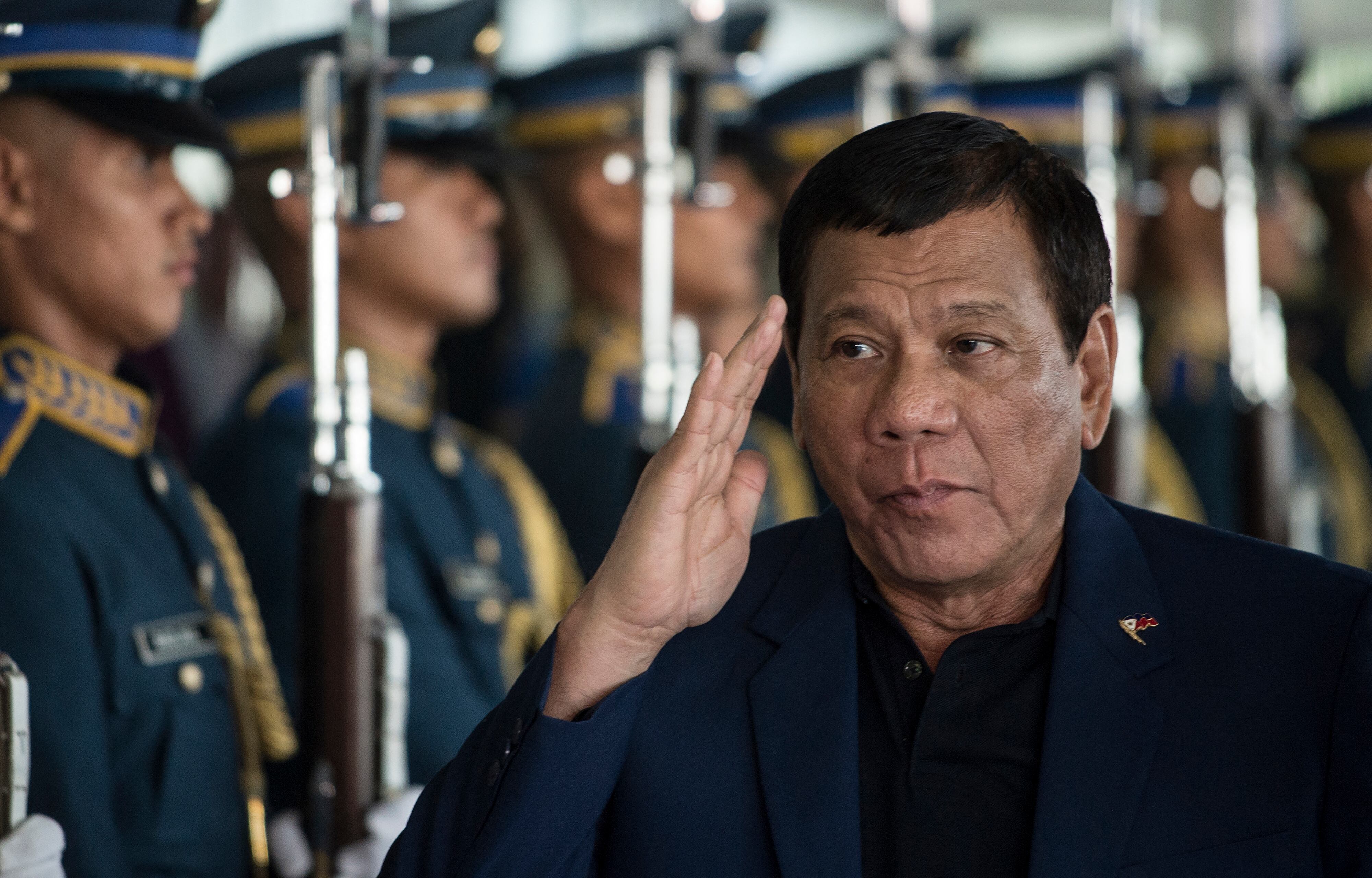 El presidente filipino Rodrigo Duterte camina entre guardias de honor a su llegada al aeropuerto internacional de Manila, el 24 de mayo de 2017. (Foto de NOEL CELIS / AFP).