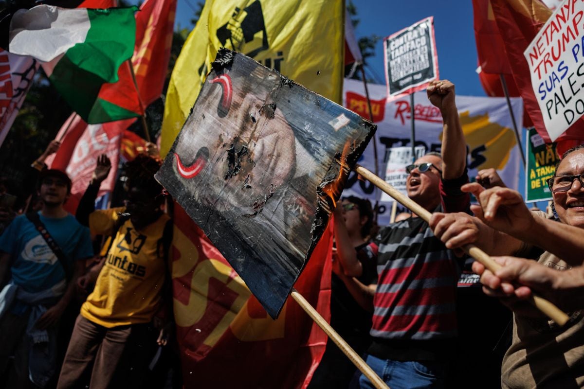 Personas sostienen carteles y banderas durante una manifestación contra los aranceles estadounidenses frente al Consulado General de Estados Unidos en São Paulo (Brasil). Foto: archivo EFE/ Isaac Fontana