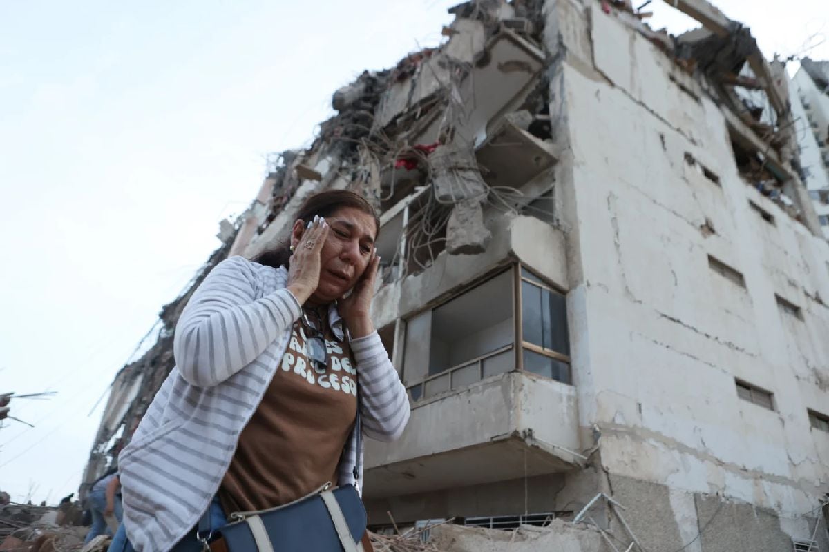 Una mujer pasa junto a un edificio dañado durante los dos terremotos que sacudieron La Guaira, Venezuela. (Foto: AP/Pedro Mattey)