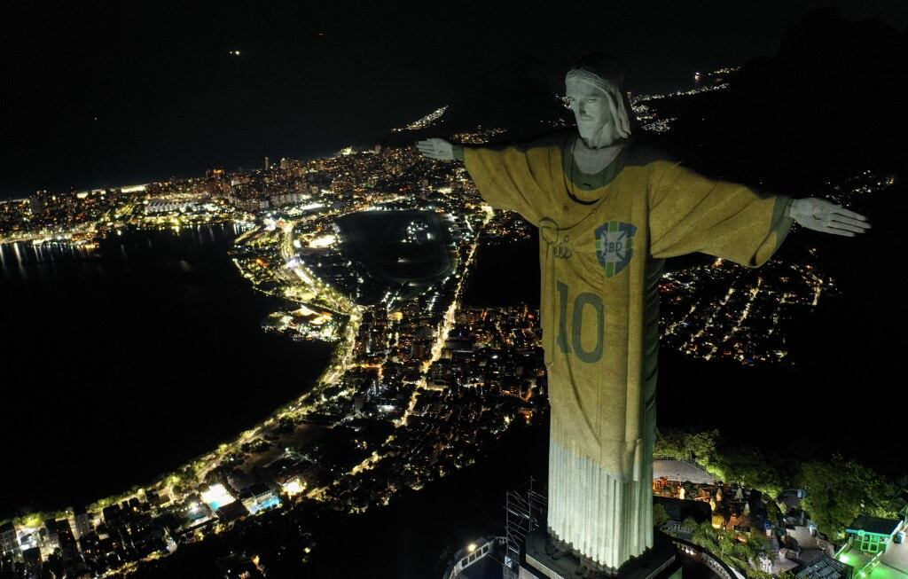 (ARCHIVOS) Vista aérea que muestra una imagen proyectada sobre la estatua del Cristo Redentor que rinde homenaje a la leyenda del fútbol brasileño Pelé en el primer aniversario de su muerte, en el Monte Corcovado en Río de Janeiro, Brasil, el 29 de diciembre de 2023. El 19 de noviembre no es Ya no es una fecha insignificante en Brasil: es el "Día del Rey Pelé", una nueva fecha conmemorativa creada para rendir homenaje al hombre que muchos consideran el mejor futbolista de todos los tiempos. (Foto de Mauro PIMENTEL / AFP)