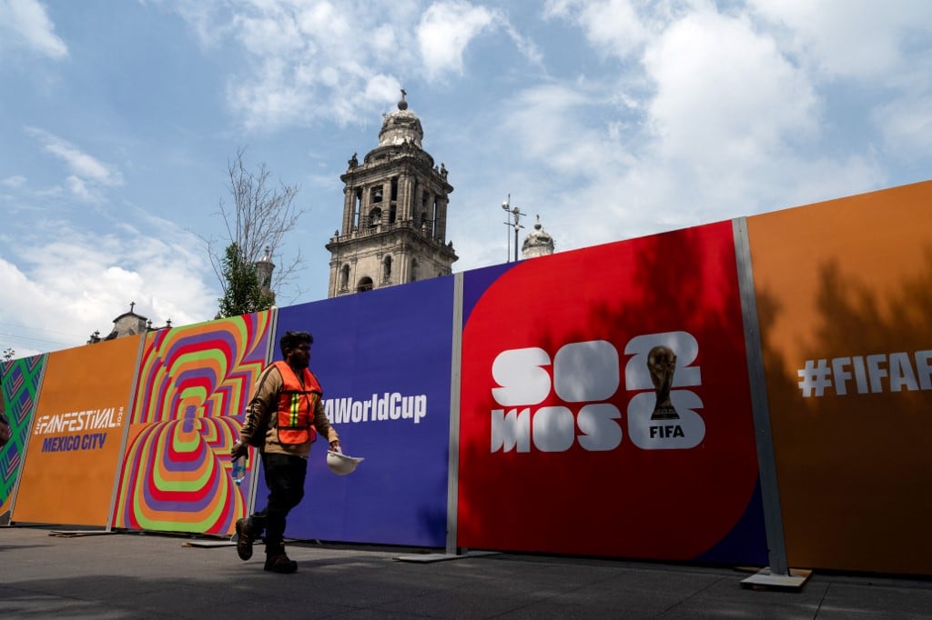 Un trabajador pasa junto a la valla de las instalaciones del FIFA Fan Fest en la Plaza del Zócalo, un día antes de la inauguración del Mundial de Fútbol de la FIFA 2026 en la Ciudad de México, el 10 de junio de 2026. (Foto de Gerardo Luna / AFP)