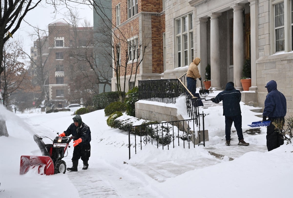 Trabajadores despejan nieve frente a un edificio residencial en Washington, DC, el 25 de enero de 2026, tras la intensa tormenta invernal que azotó gran parte de EE. UU. | Crédito: Mandel NGAN / AFP