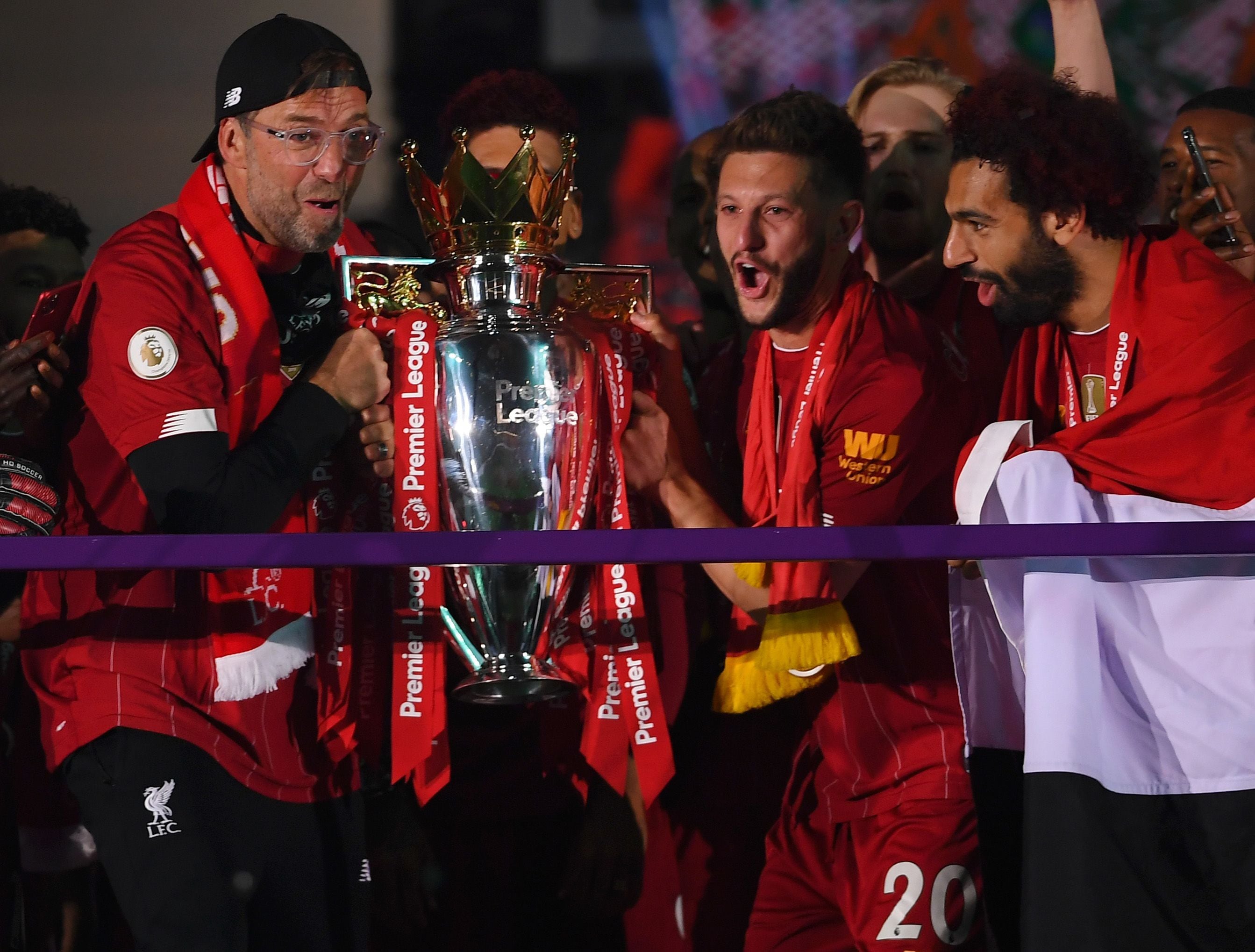 Jürgen Klopp, Adam Lallana y Mohamed Salah del Liverpool sostienen el trofeo de la Premier League para celebrar la victoria en la ceremonia de entrega del título de liga durante el partido de la Premier League entre el Liverpool FC y el Chelsea FC en Anfield el 22 de julio de 2020 en Liverpool, Inglaterra.