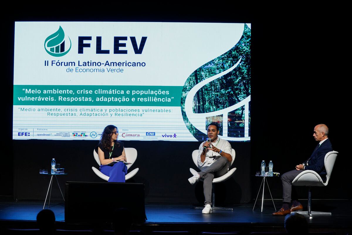 BRA100. SAO PAULO (BRASIL), 02/10/2024.- El presidente de la organización G10 Favelas, Gilson Rodrigues (c), habla junto a el representante del Programa de las Naciones Unidas para el Desarrollo (PNUD) en Brasil, Claudio Providas (d) y la moderadora Isadora Camargo, durante el segundo día del II Foro Latinoamericano de Economía Verde, este miércoles en São Paulo (Brasil). En las favelas de Brasil, hogar de unos 20 millones de personas, sienten desde hace años los efectos de una crisis climática que ha obligado a sus habitantes a poner en marcha sus propias iniciativas sostenibles ante el abandono del Estado. EFE/ Isaac Fontana