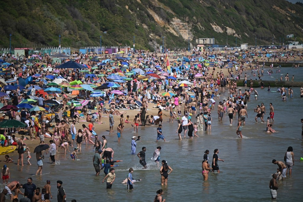 Los bañistas juegan en el mar y se relajan bajo el sol en la playa de Bournemouth, en la costa sur de Inglaterra, el 26 de mayo de 2026, mientras la ola de calor se extendía por el sureste de Inglaterra y Londres. Gran Bretaña registró el martes la temperatura más alta jamás registrada en mayo, alcanzando los 35 °C cerca de la capital. (Foto de JUSTIN TALLIS / AFP)