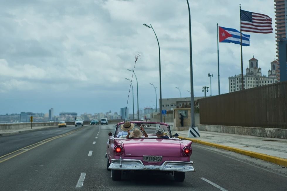 Un auto clásico estadounidense lleva a turistas junto a la embajada de Estados Unidos en La Habana, el lunes 20 de abril de 2026. (AP Foto/Ramón Espinosa)