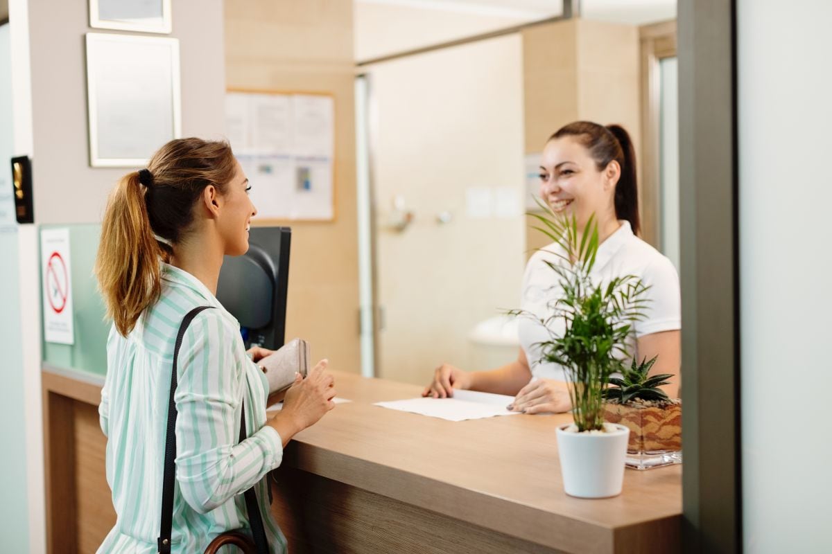 Una persona siendo atendida por una recepcionista en un hotel (Foto: Freepik)