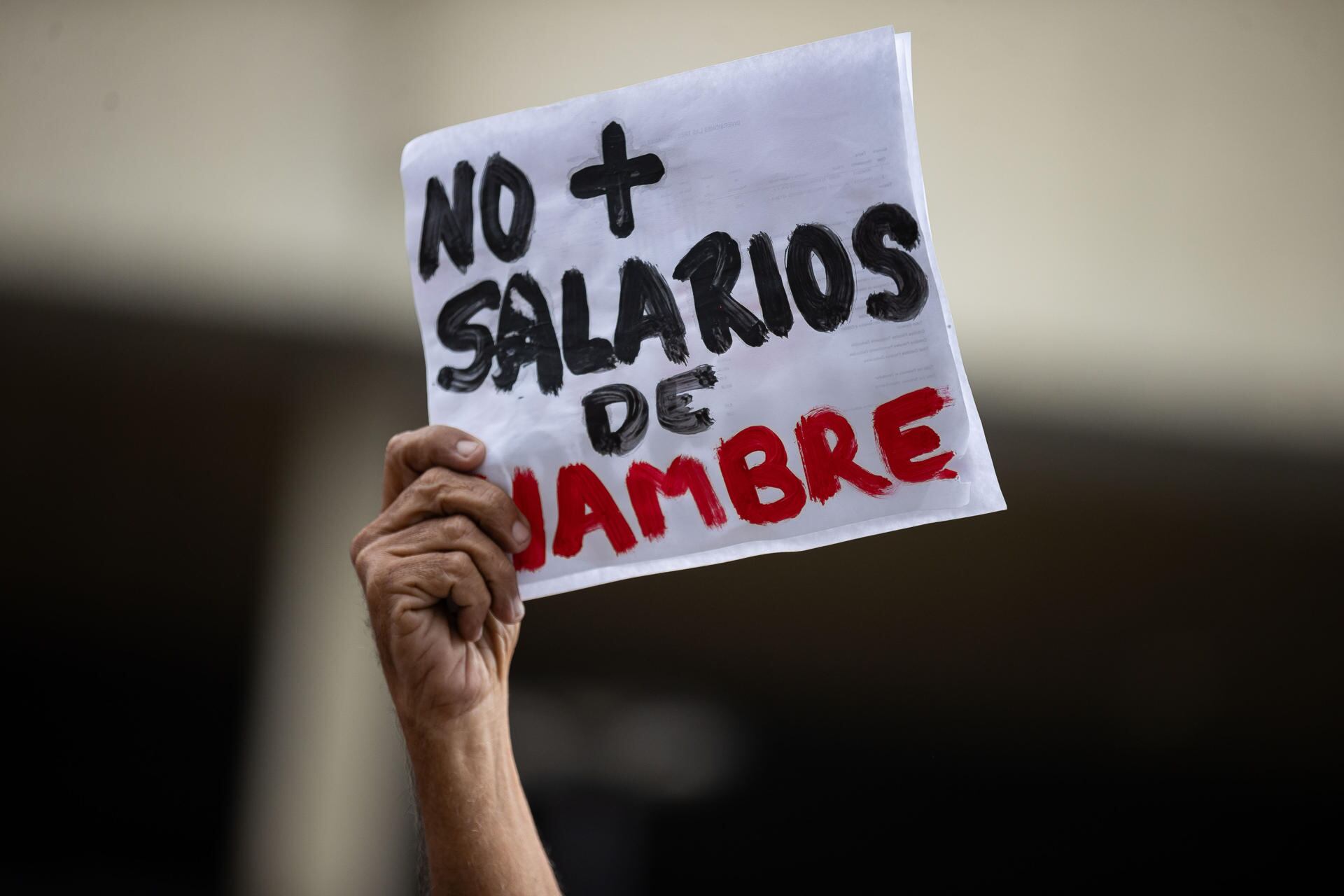 Una persona sostiene un cartel durante una manifestación para exigir el aumento del salario mínimo en Caracas, Venezuela. (EFE/ Ronald Pena R).