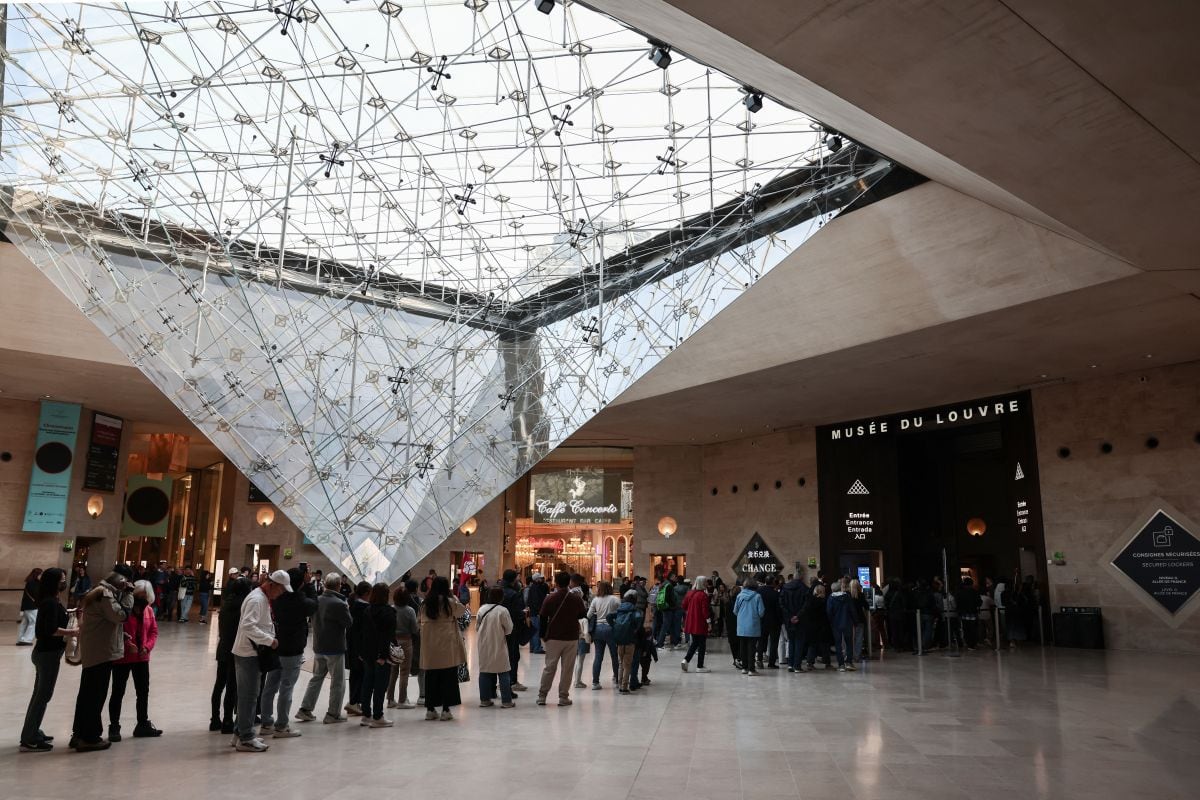 Los visitantes hacen cola para entrar en el Museo del Louvre, junto a la Pirámide del Louvre, diseñada por el arquitecto chino-estadounidense Ieoh Ming Pei en París, el 22 de octubre de 2025. Foto: Thibaud MORITZ / AFP