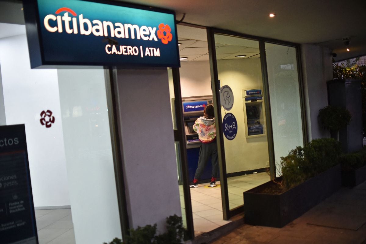 Una mujer retira dinero de un cajero automático de Citibanamex en la Ciudad de México, el 11 de enero de 2022. (Foto de RODRIGO ARANGUA / AFP)
