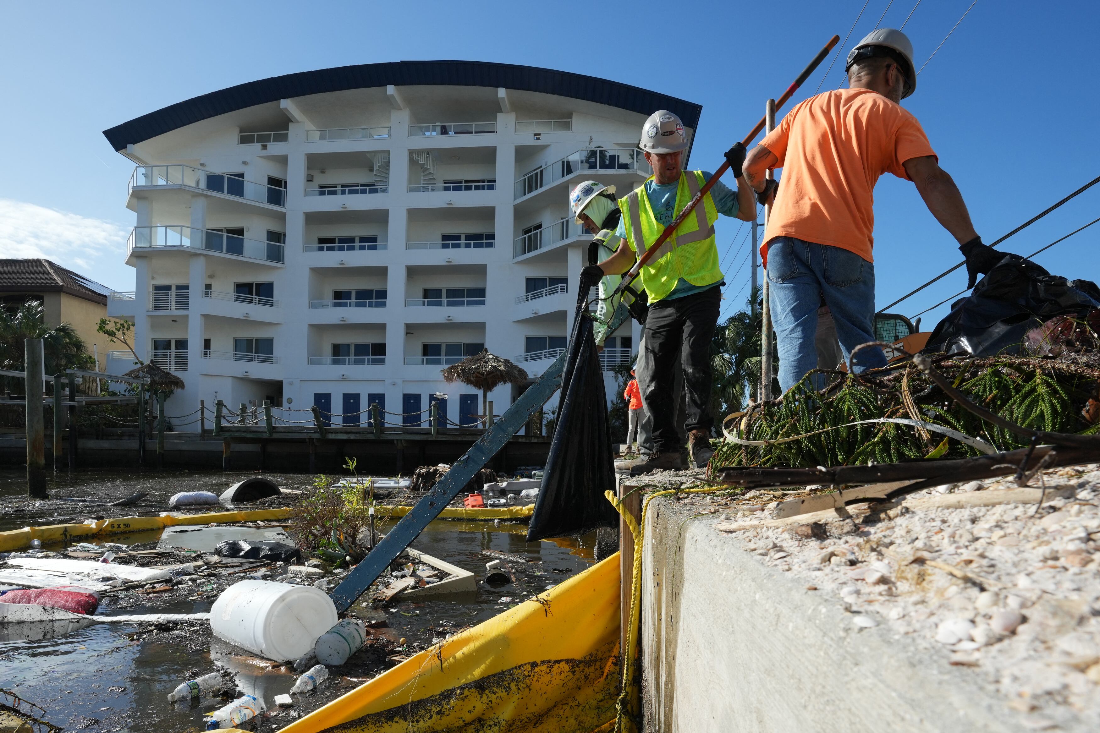 Unos contratistas trabajando para retirar la basura y los escombros de Clearwater Bay en Clearwater Beach, Florida, tras el paso del huracán Milton el 11 de octubre de 2024 (Foto: AFP)