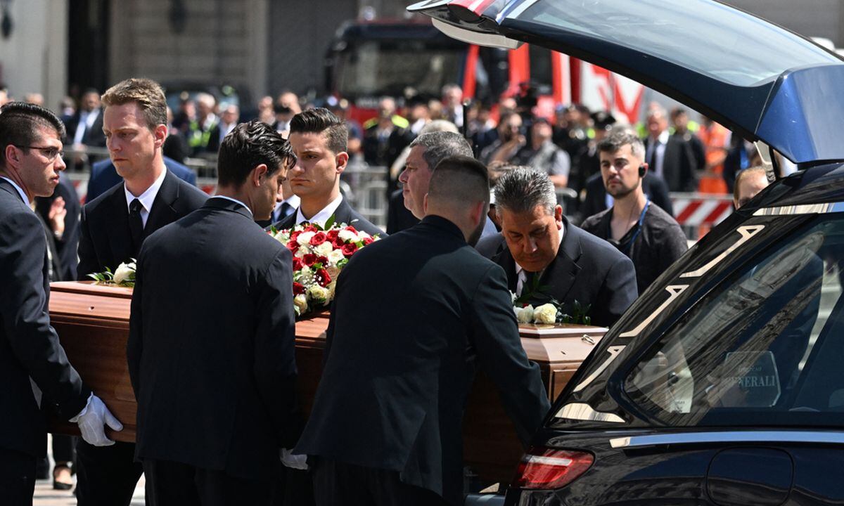 Los portadores del féretro llevan el ataúd del ex primer ministro italiano y magnate de los medios, Silvio Berlusconi, desde el coche fúnebre en la catedral del Duomo de Milán el 14 de junio de 2023 para el funeral de estado de Berlusconi (Foto: Andreas SOLARO / AFP)