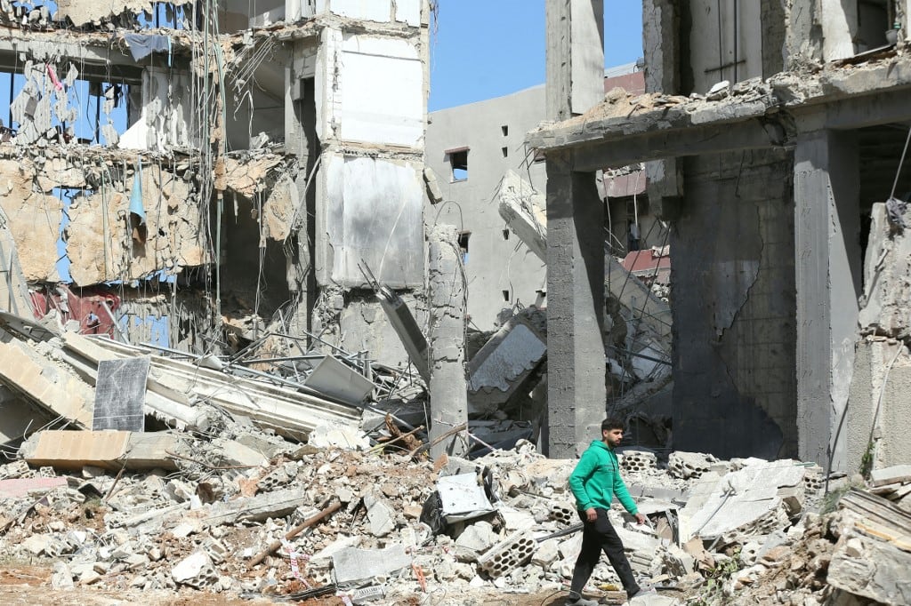 Un hombre pasa junto al lugar donde un ataque aéreo israelí tuvo como objetivo un complejo religioso chiíta el día anterior en la ciudad costera de Sidón, al sur del Líbano, el 9 de abril de 2026. (Foto de Mahmoud ZAYYAT / AFP)