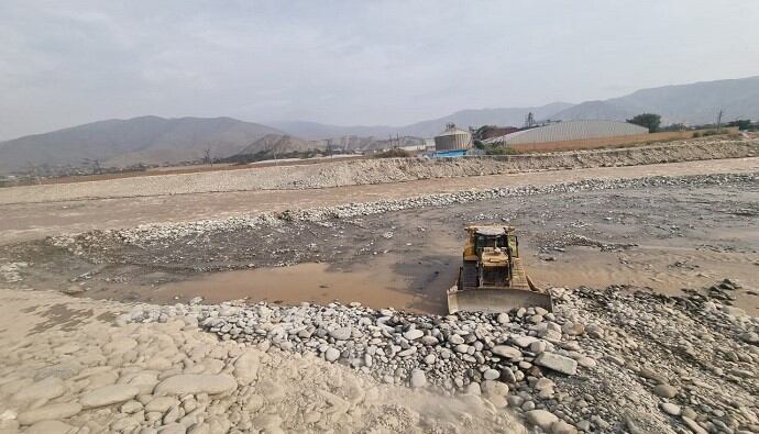 Con apoyo de maquinaria se realiza el encauzamiento y enrocado en margen derecha del río hablador a fin de proteger a la población ante lluvias por el fenómeno El Niño. Foto: MVCS.