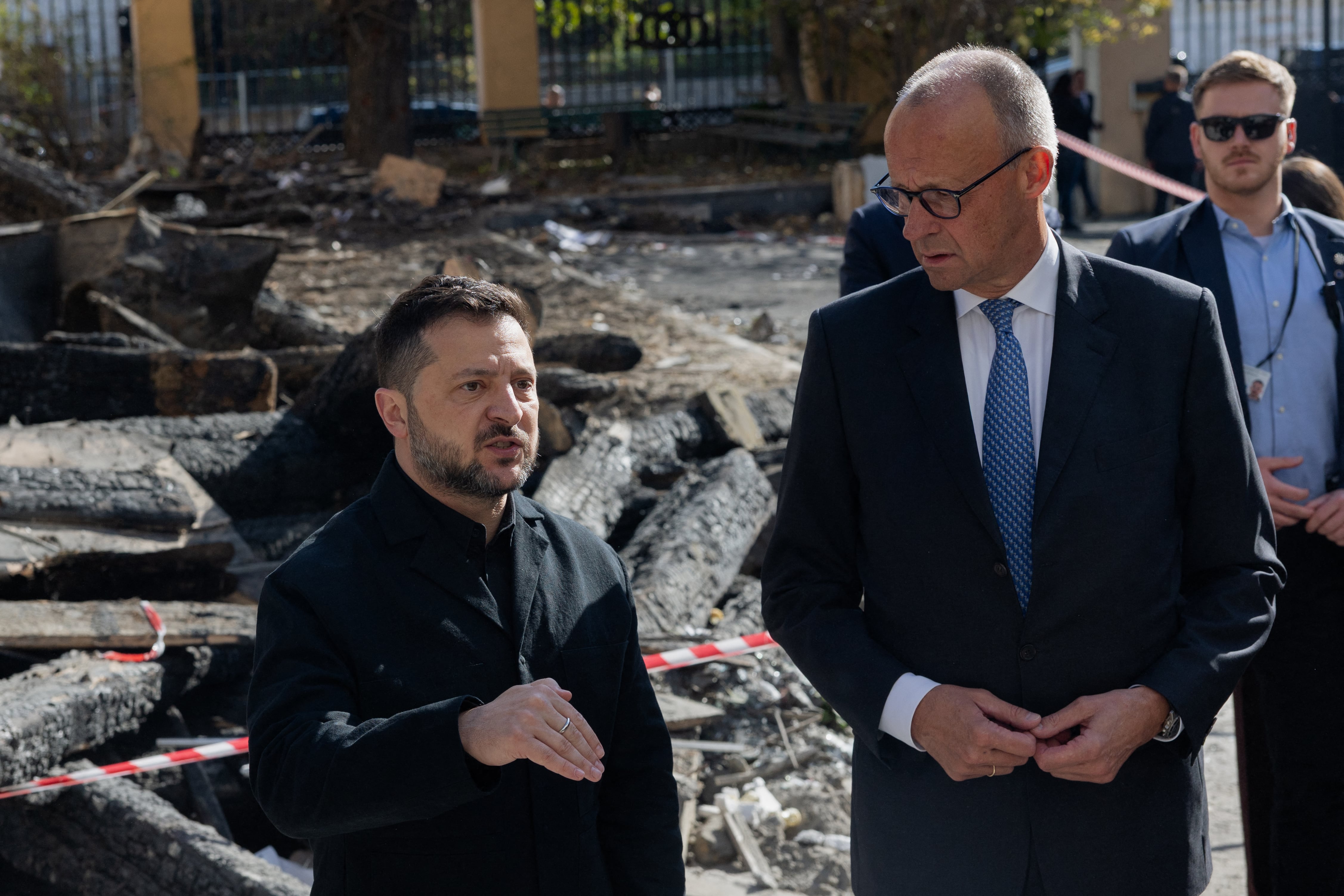 El presidente de Ucrania, Volodymyr Zelensky (izquierda), y el canciller de Alemania, Friedrich Merz, visitan el edificio dañado de la Academia de Ciencias de Ucrania en Kiev el 4 de octubre de 2026. (Foto de Tetiana Dzhafarrova / AFP).