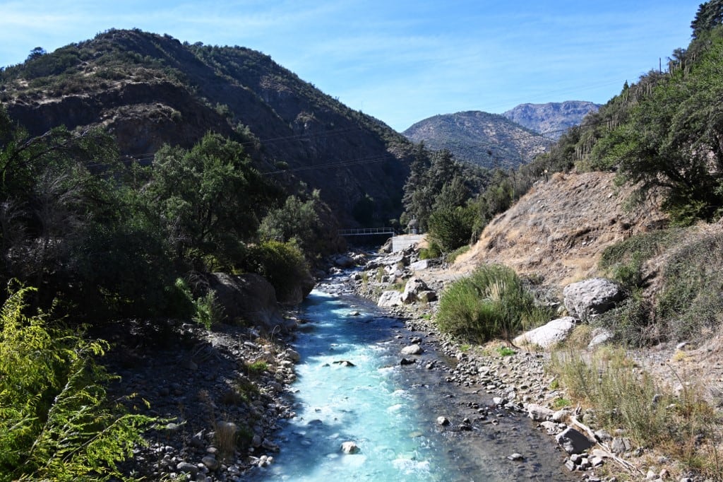 Vista del río Mapocho fluyendo por su cauce en las estribaciones andinas, en las afueras de Santiago, el 28 de abril de 2026. (Foto de RODRIGO ARANGUA / AFP)