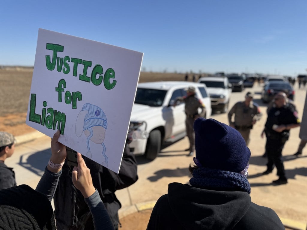 Un manifestante sostiene un cartel contra el ICE durante una manifestación y vigilia frente al Centro Residencial Familiar del Sur de Texas en Dilley, Texas, el 28 de enero de 2026. (Foto de Moisès VILA / AFP)