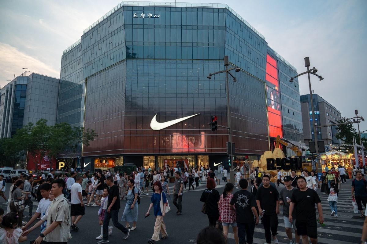 Peatones pasan por una tienda de Nike Inc. en la zona comercial de Wangfujing en Beijing, China, el lunes 11 de julio de 2024.