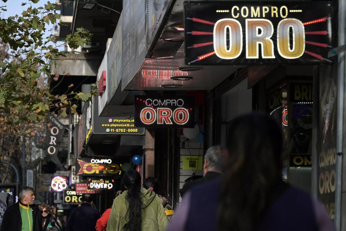 Unos carteles de comercios de compra de oro en Buenos Aires| imagen de Juan Mabromata / AFP