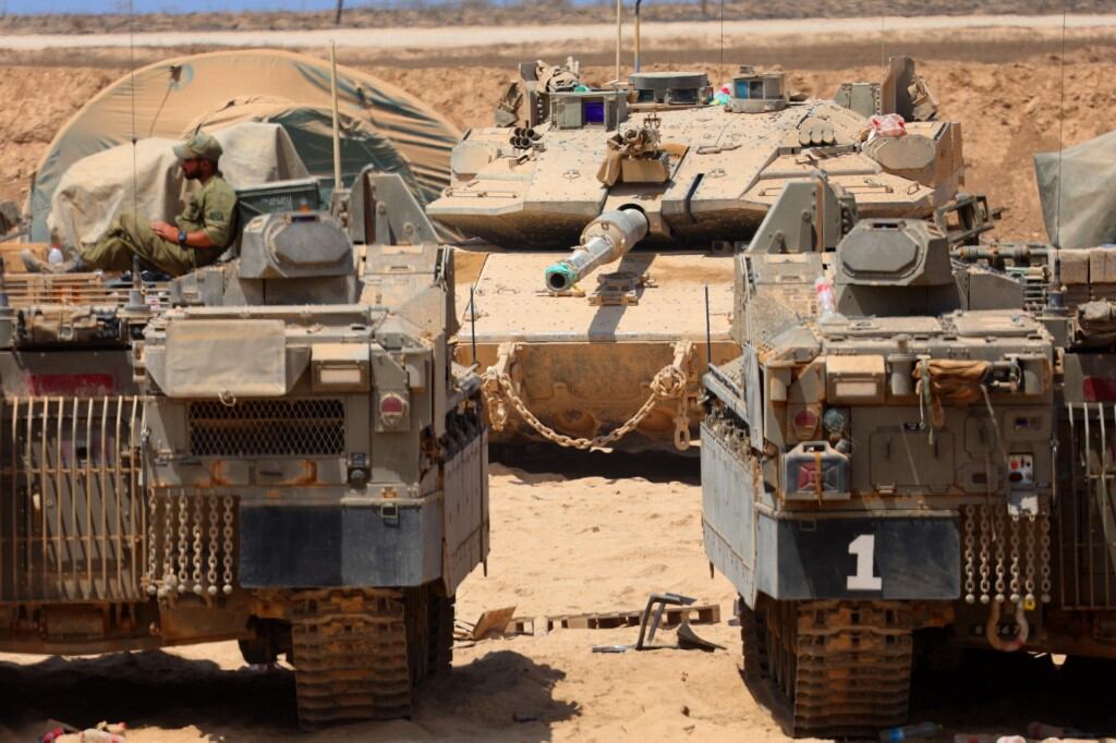 Israeli military vehicles are positioned along the border with the Gaza Strip on August 21, 2025. Israel hammered Gaza City and its outskirts overnight, residents said on August 20, as the military announced it had taken initial steps in its push to capture Hamas's last major stronghold. (Photo by Jack GUEZ / AFP)
