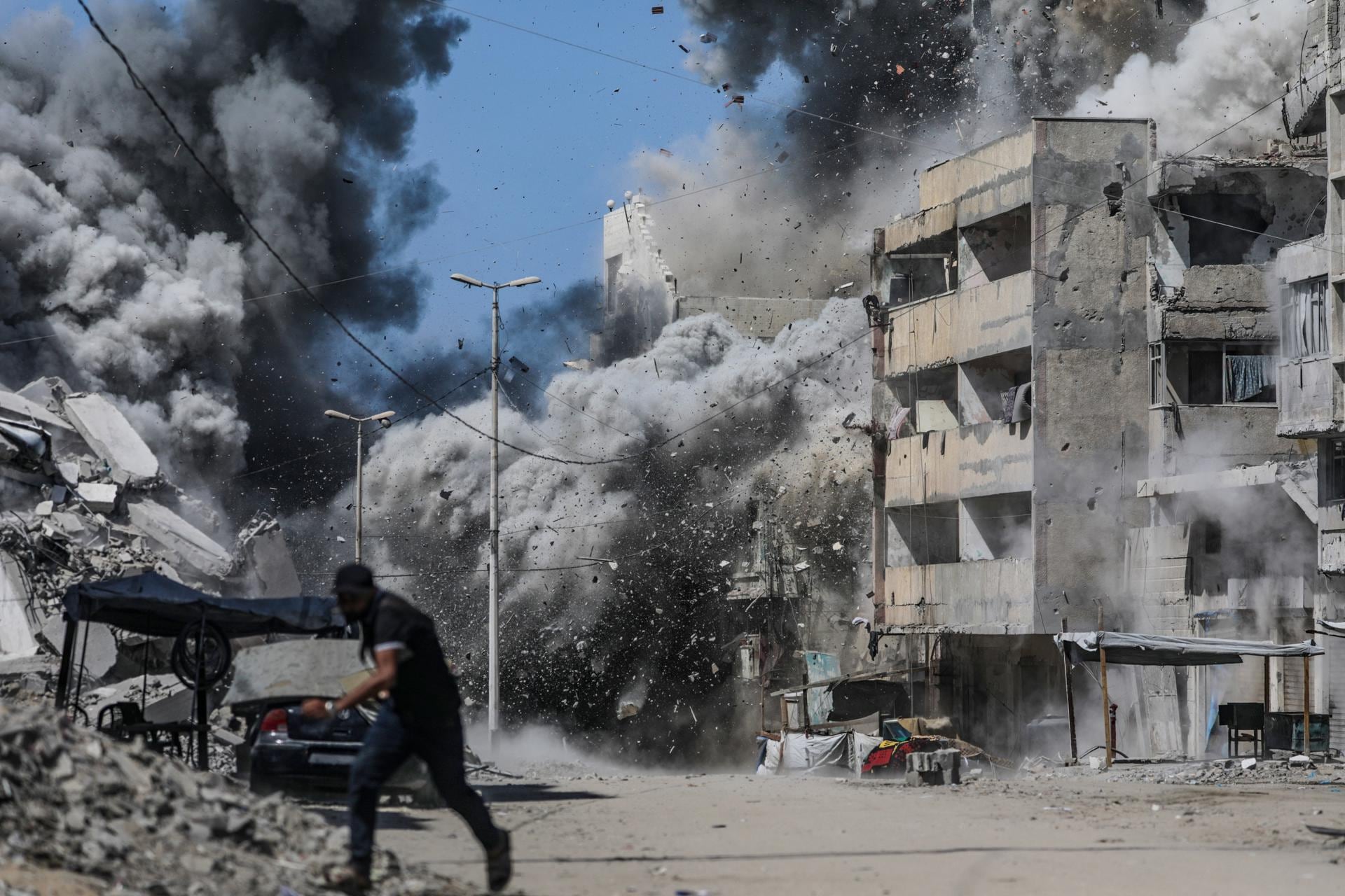 Un palestino se refugia tras un ataque aéreo israelí durante una operación militar en la ciudad de Gaza, el 27 de septiembre de 2025. (EFE/EPA/MOHAMMED SABER).