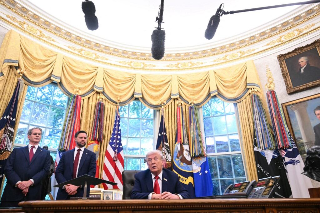 El presidente de EE.UU., Donald Trump, habla ante la prensa tras firmar una orden ejecutiva sobre TikTok en el Despacho Oval de la Casa Blanca en Washington, D.C., el 25 de septiembre de 2025, mientras el secretario del Tesoro, Scott Bessent (izq.), y el vicepresidente, J. D. Vance, observan. (Foto de SAUL LOEB / AFP)